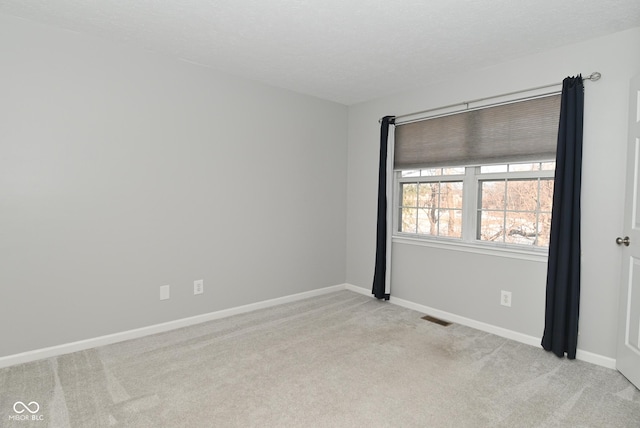 carpeted empty room with a textured ceiling