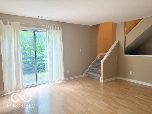 6639 N College Ave, Indianapolis, IN 46220 - unfurnished living room with light wood-style floors, baseboards, and stairs