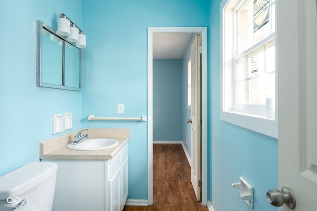 bathroom with vanity, hardwood / wood-style floors, and toilet