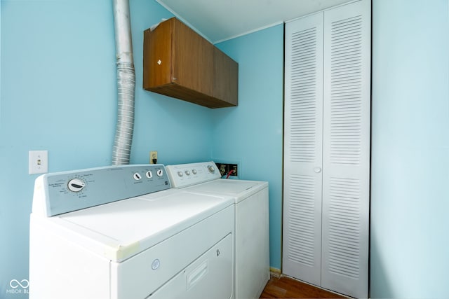 clothes washing area featuring cabinets and washing machine and dryer