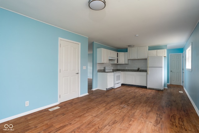 kitchen featuring sink, white appliances, dark wood-type flooring, and decorative backsplash