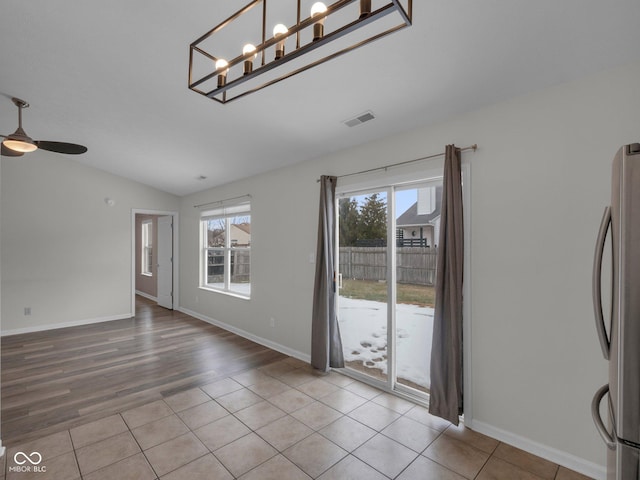 unfurnished dining area featuring lofted ceiling, plenty of natural light, ceiling fan, and light hardwood / wood-style flooring