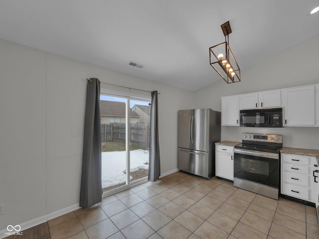 kitchen featuring light tile patterned flooring, appliances with stainless steel finishes, vaulted ceiling, white cabinetry, and hanging light fixtures