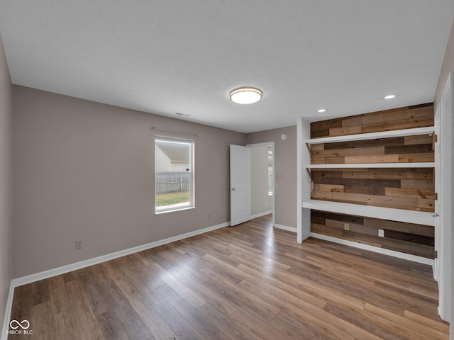 unfurnished living room with hardwood / wood-style flooring and a textured ceiling