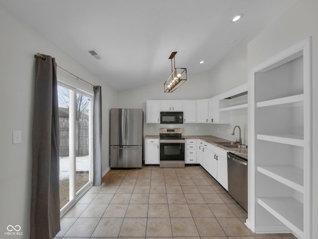 kitchen with light tile patterned flooring, sink, white cabinetry, hanging light fixtures, and appliances with stainless steel finishes