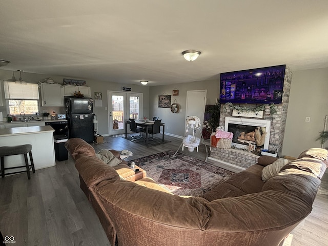 living room with hardwood / wood-style floors, a fireplace, and sink