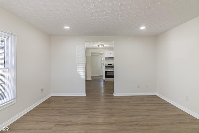 unfurnished room featuring dark wood-style floors, recessed lighting, a textured ceiling, and baseboards