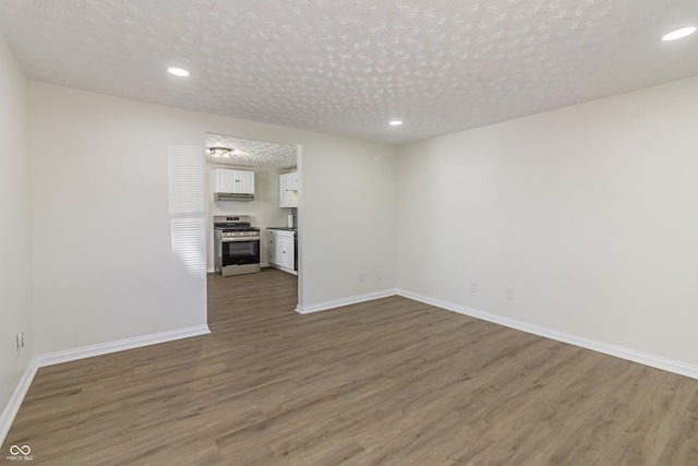 unfurnished living room with dark wood-type flooring and a textured ceiling