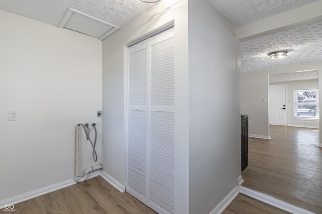 corridor featuring hardwood / wood-style floors and a textured ceiling