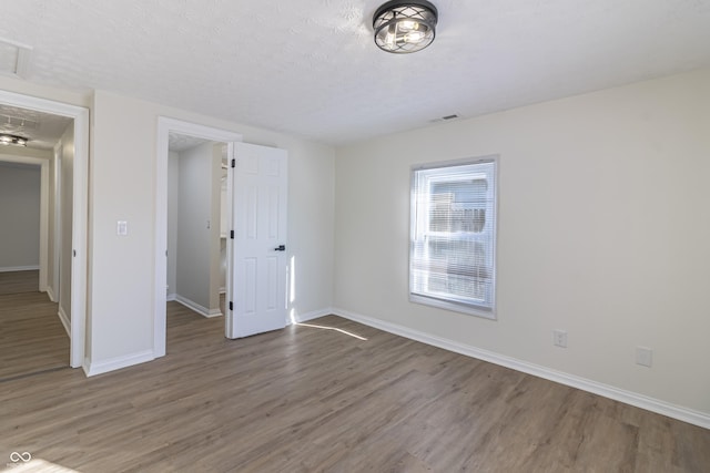 unfurnished bedroom featuring hardwood / wood-style floors and a textured ceiling