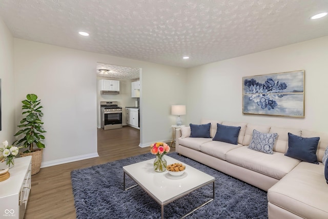 living room with dark wood-style floors, recessed lighting, a textured ceiling, and baseboards