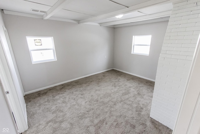 carpeted empty room with beamed ceiling