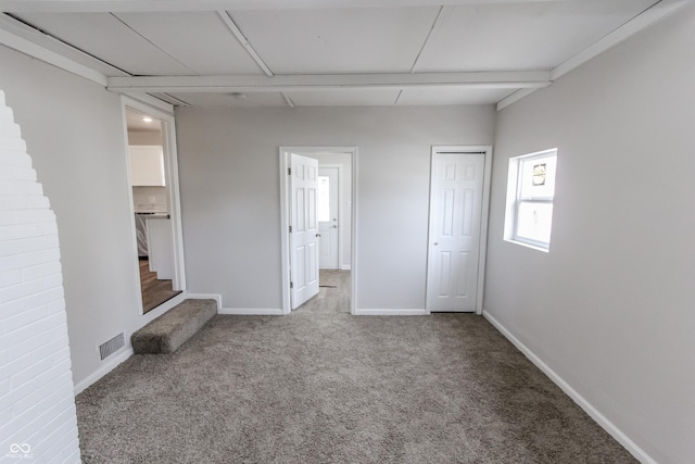 unfurnished bedroom with ensuite bathroom, carpet, and a closet