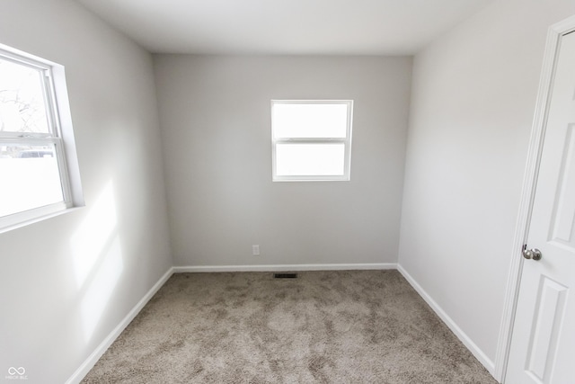 spare room featuring light colored carpet