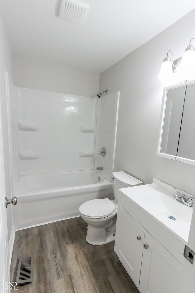 full bathroom featuring shower / bath combination, vanity, hardwood / wood-style floors, and toilet