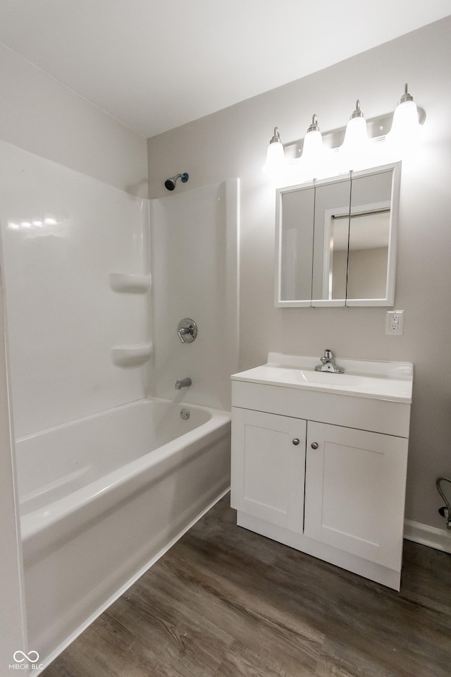 bathroom with hardwood / wood-style flooring, shower / bathtub combination, and vanity