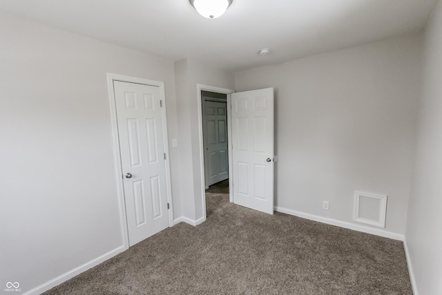 unfurnished bedroom with dark colored carpet