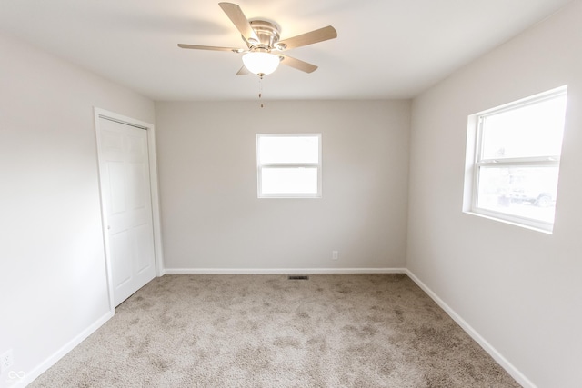 carpeted spare room with ceiling fan