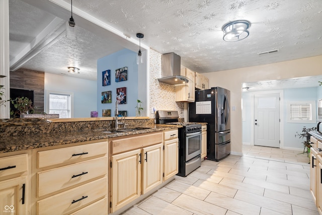 kitchen with wall chimney exhaust hood, sink, light brown cabinets, dark stone counters, and stainless steel appliances