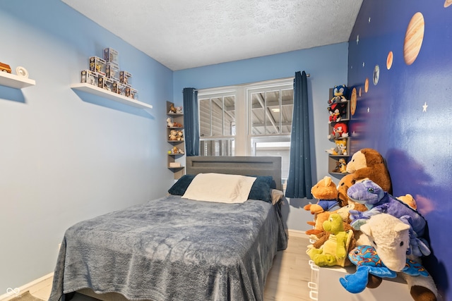 bedroom featuring a textured ceiling and light hardwood / wood-style floors