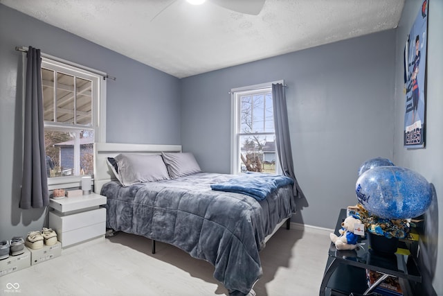 bedroom with ceiling fan and a textured ceiling