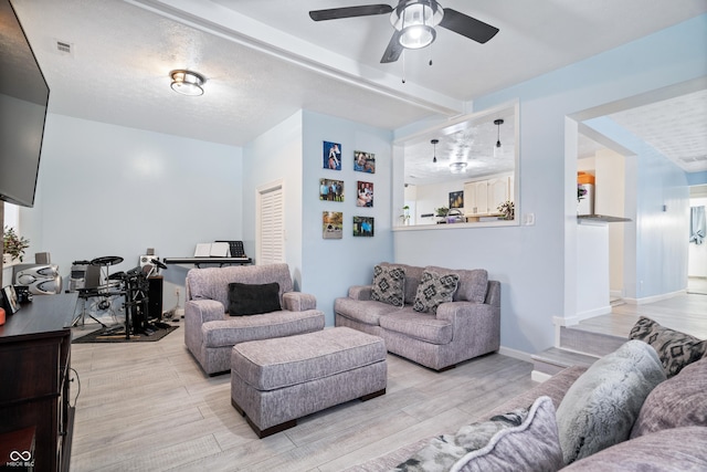 living room featuring a textured ceiling and ceiling fan