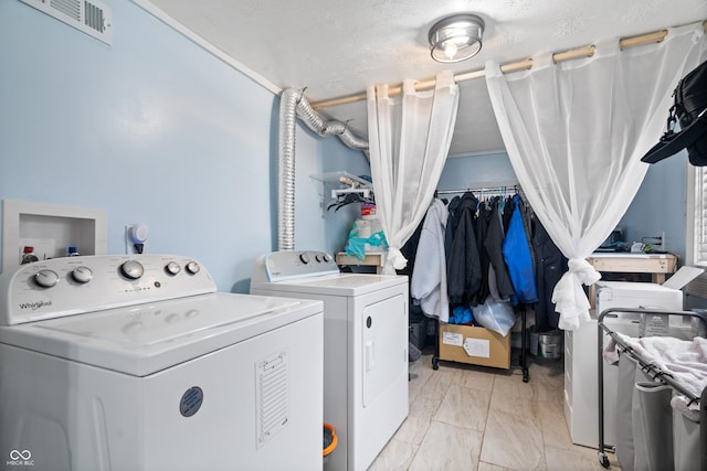 washroom featuring washing machine and clothes dryer and a textured ceiling