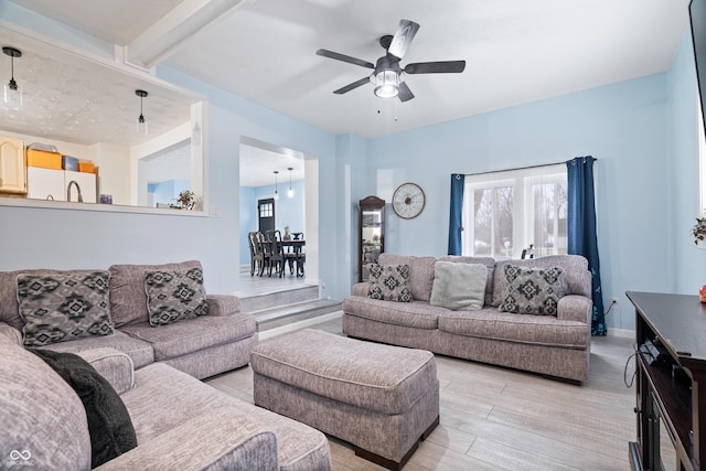 living room with ceiling fan, plenty of natural light, and light hardwood / wood-style floors