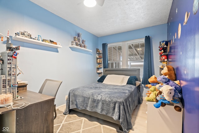 bedroom featuring light wood-type flooring and a textured ceiling