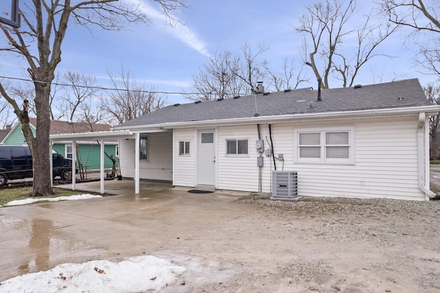 back of house featuring cooling unit and a carport