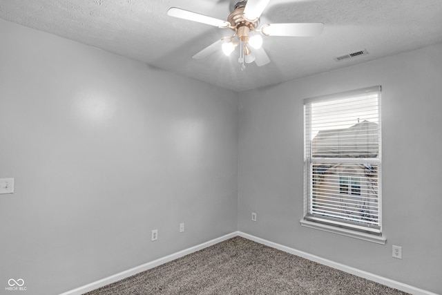 carpeted spare room featuring ceiling fan and a textured ceiling