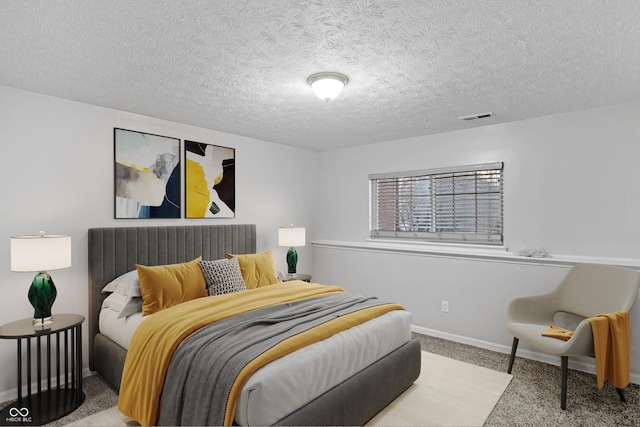 bedroom featuring light carpet and a textured ceiling