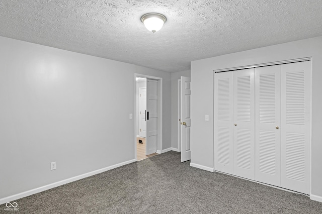 unfurnished bedroom with a closet, a textured ceiling, and dark colored carpet