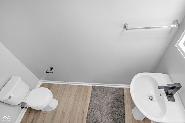 bathroom featuring wood-type flooring, toilet, and sink