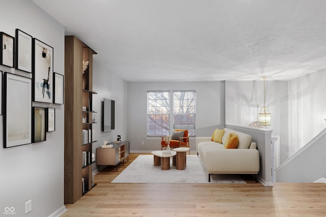 living room featuring a textured ceiling and light wood-type flooring