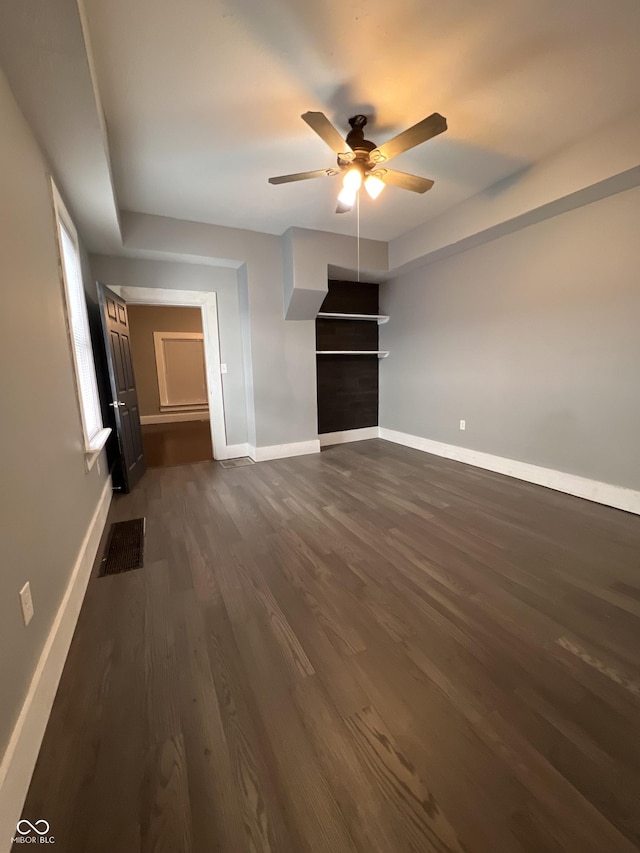 unfurnished living room with dark hardwood / wood-style flooring and ceiling fan