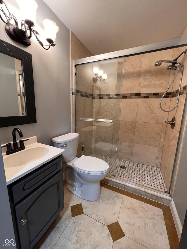 bathroom featuring vanity, toilet, and a shower with shower door