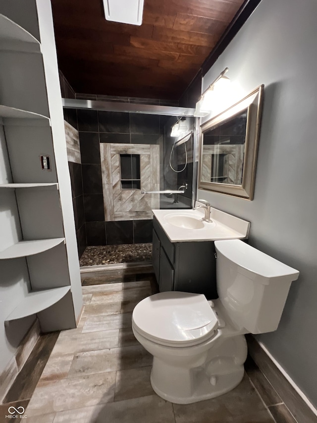 bathroom featuring vanity, tiled shower, wood ceiling, and toilet