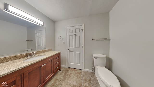 bathroom with vanity, a textured ceiling, and toilet