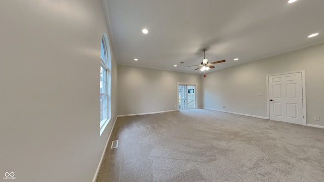 carpeted spare room featuring ceiling fan and ornamental molding