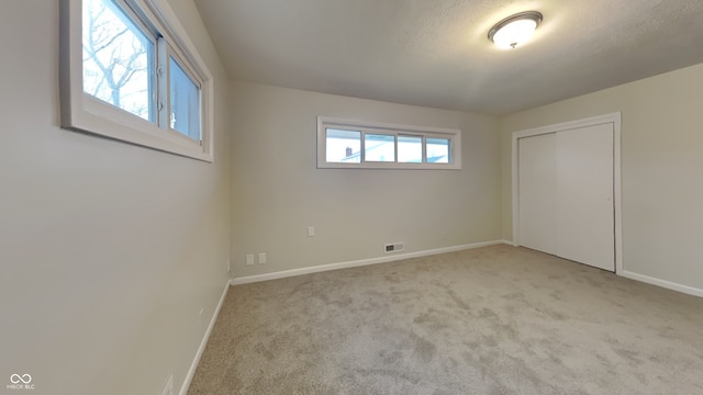 carpeted spare room featuring a textured ceiling