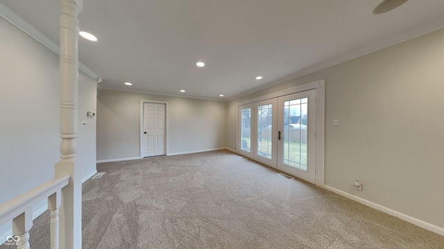 carpeted spare room with ornamental molding and french doors