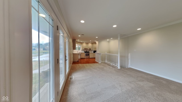 spare room with ornamental molding and light colored carpet