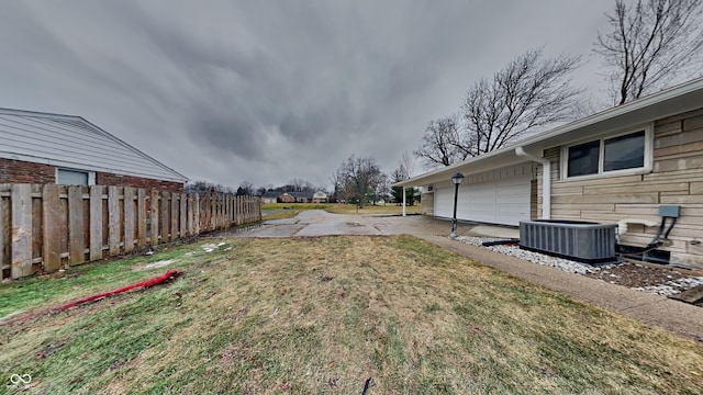 view of yard featuring a garage and cooling unit