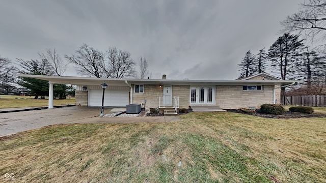 back of property featuring a garage, a yard, a carport, and central AC unit