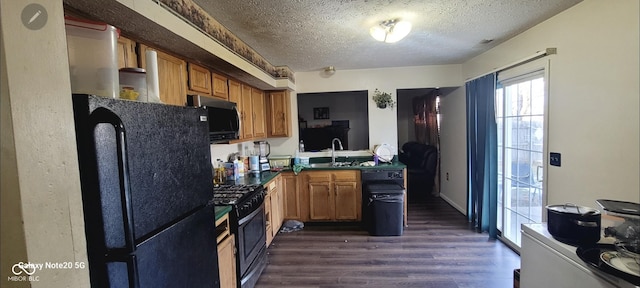 kitchen with stainless steel appliances, sink, a textured ceiling, and dark hardwood / wood-style flooring