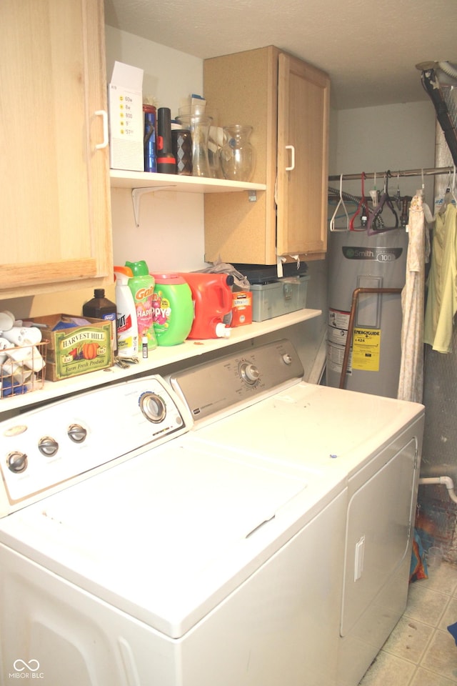 clothes washing area with cabinets, electric water heater, and washing machine and dryer