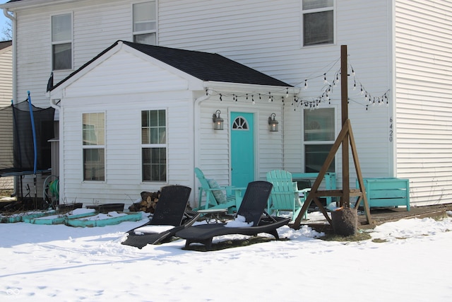 view of snow covered rear of property