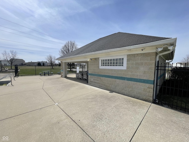7842 Cork Bend Ln, Indianapolis, IN 46239 - view of property exterior with a shingled roof, fence, concrete block siding, and a patio area