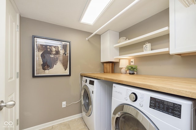 washroom featuring separate washer and dryer, light tile patterned floors, and cabinets